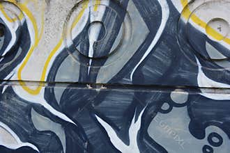 Graffiti depicting the word MAM on white, gray concrete fence.