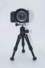 Camera on tripod ready for photography session in studio setting with neutral background
