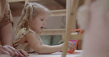 Young Girl Learning with Abacus at Home with Parent: A Heartwarming Moment of Family Time and Education