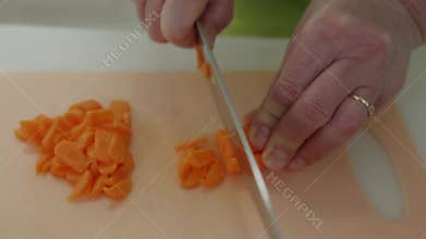 Chef slicing carrots on cutting board