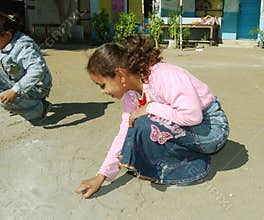 Young girl drawing with chalk at school