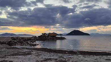 Trucks are dumping rocks and debris into the sea for the construction of the marina.