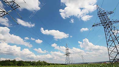 panorama with tall electric masts against cloudy sky