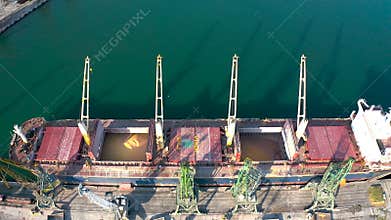 Top view from a drone of a large ship loading grain for export.