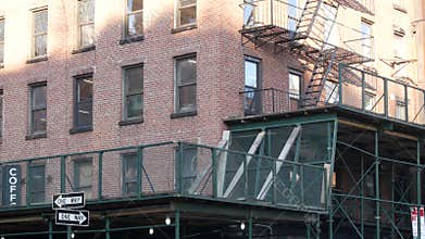 New York City building architecture, Manhattan. Residential house exterior. Red brick, fire escape.