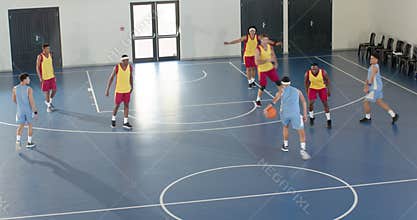 Basketball players competing intensely on indoor court during practice game