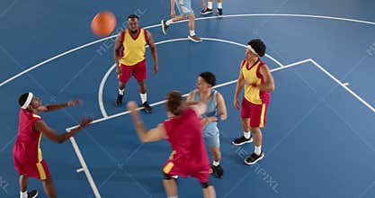 Players competing intensely on basketball court, focusing on making shot