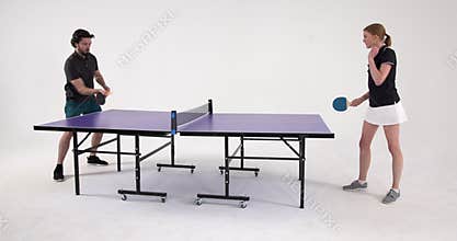 Playing table tennis, man and woman competing in friendly match indoors