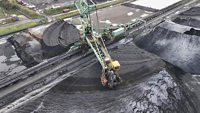 Flying over industrial port and warehouse for fossil fuels, coal and ore in the open air.