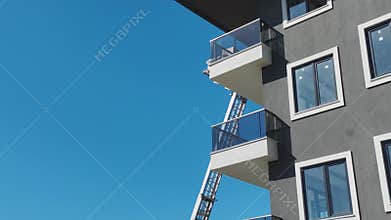 Aerial View: Workers carefully use a lift to load furniture through a balcony onto the topmost floors.