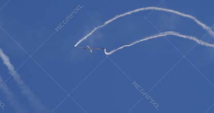 Extreme Glider Aerobatics with White Smoke Trails in Clear Blue Sky