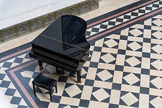 Black piano on geometric tiled floor in a room from above