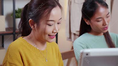 Two young asian woman working while planning online business and checking order with writing on tablet at home, retail with online