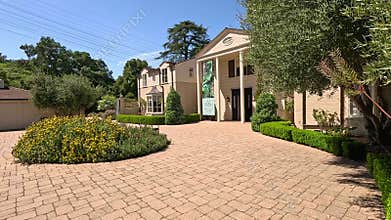 footage of the Boddy House museum with colorful flowers and lush green trees and plants at Descanso Gardens La Canada Flintridge