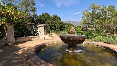 footage of a water fountain with lush green trees and plants and colorful flowers at Descanso Gardens