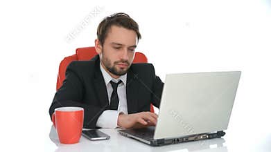 Businessman sitting working at his laptop