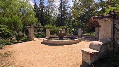 footage of a water fountain with lush green trees and plants and colorful flowers at Descanso Gardens