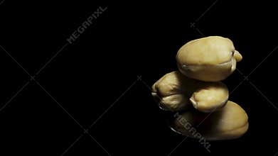 cashew nuts rotate, on a black background close-up. In move