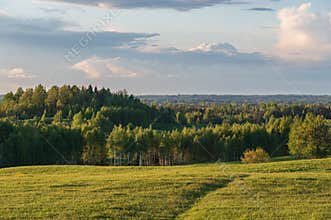 Agricultural fields and forests on the hills in the evening light