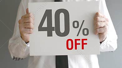 Salesman holding sale tag with forty percent sales discount price. Consumerism concept.