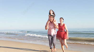 Father Carrying Daughter On Shoulders Running Out Of Sea