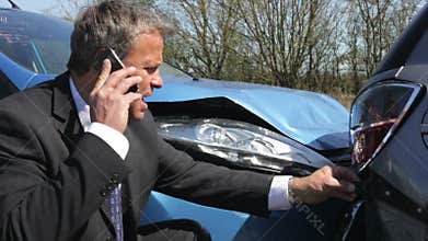 Businessman Making Phone Call After Traffic Accident