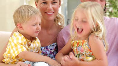 Family Sitting On Garden Seat Together