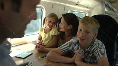 Family Relaxing On Train Journey