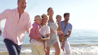Multi Generation Family Running Along Beach