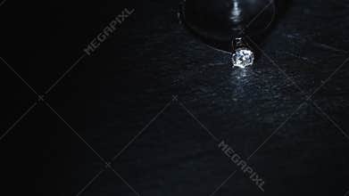 A diamond ring appears in a beam of light.