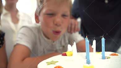 Slow Motion Sequence Of Boy Blowing Out Candles On Cake