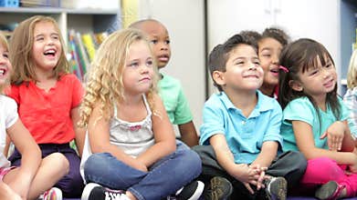 Group Of Elementary Age Schoolchildren Sitting On Floor