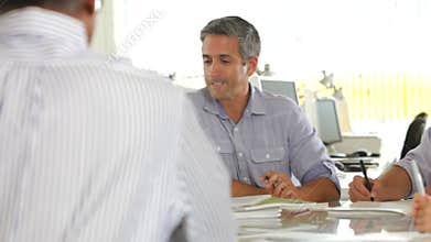Team Meeting Around Table In Creative Office