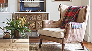 A bright and airy living room showcases a striking armchair with a distinct, vintage-inspired design. A Generative AI