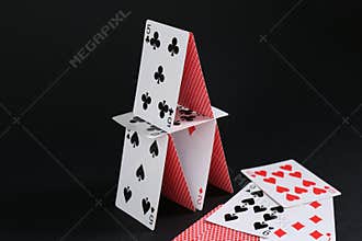 House of playing cards on black background