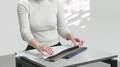 tailor examines fabrics, accessories, threads, sewing devices and other