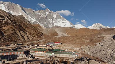 erial perspective of a tranquil Himalayan village in Nepal, showcasing cultural architecture and towering snowy summits