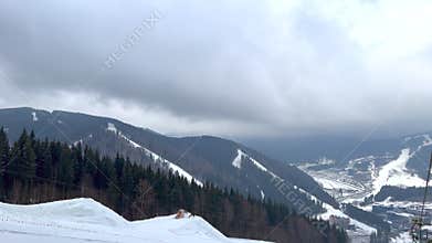 Clouds moving over snowy mountain ski slopes