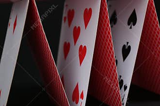 House of playing cards on black background, closeup