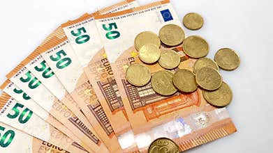 Fifty-euro banknotes arranged in a fan shape with cent coins