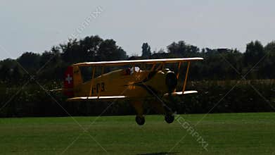 Bucker Bu 133 Jungmeister RC model landing on a grass field