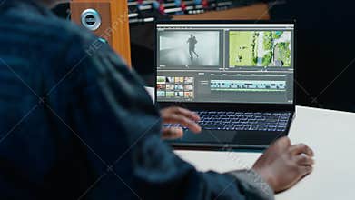 Videographer splicing film pieces on laptop, editing them