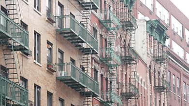 New York City building architecture, Manhattan. Residential house exterior. Red brick, fire escape.