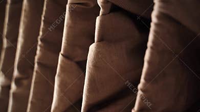 Closeup of elegantly draped brown fabrics in gentle motion highlighting texture