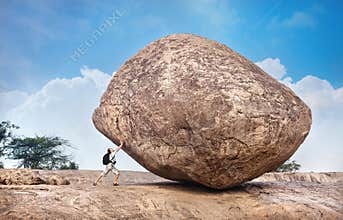 Man pushing a big stone