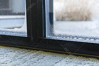 Close up of double glazed window door condensation causes by excessive moisture in the house in winter occurs when the seal