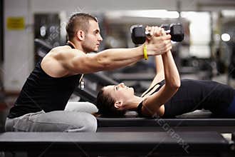 Personal trainer helping woman at gym