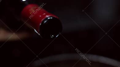 Wine pours slowly from the bottle