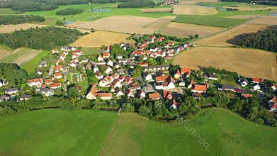 Aerial 4K drone flight over a typical provincial German village. Many small houses in the middle of the field