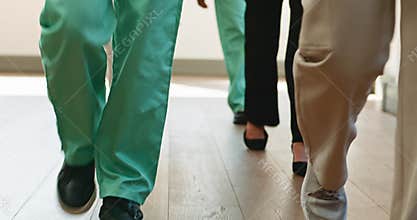 Medical Team Walking Down Hospital Hallway: Teamwork, Efficiency, and Dedication in Healthcare